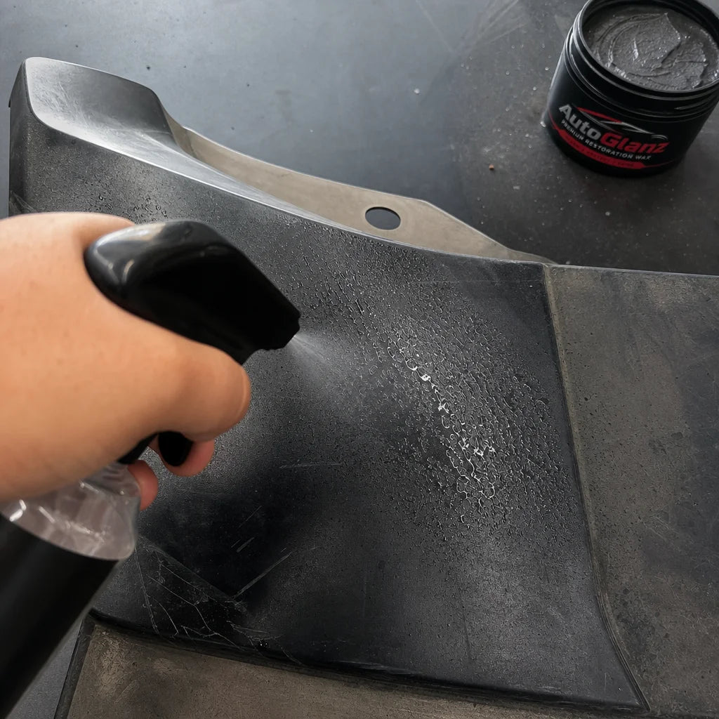 Square format top-down photograph of step 1: cleaning a car plastic bumper. A hand (with realistic s